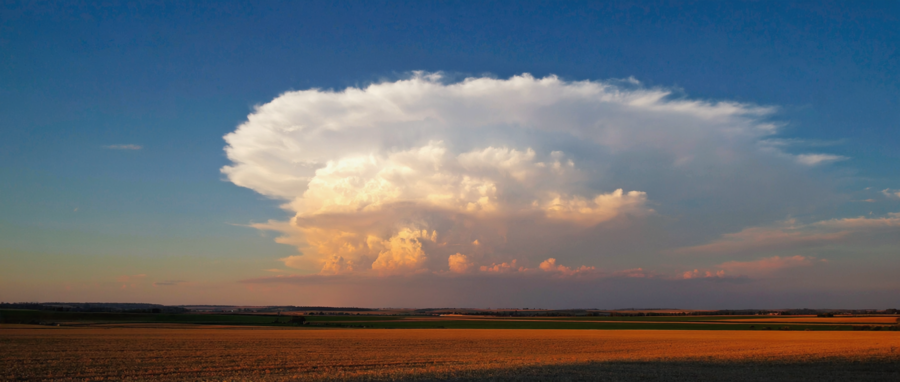Dramatischer Cumulonimbus-Wolkenturm über einer flachen Landschaft